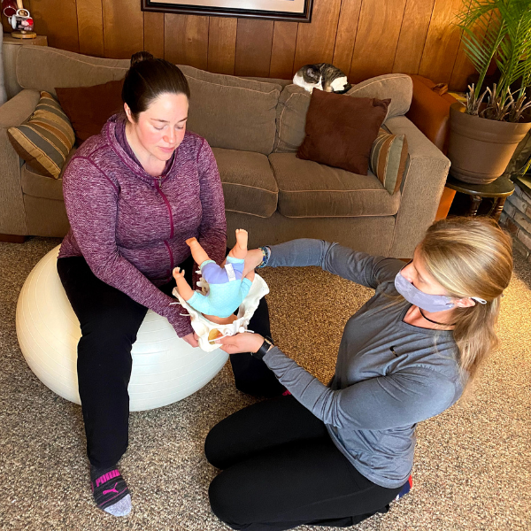 prenatal trainer Beth Colucci Foppiano shows a pregnant client how her baby will move through her pelvis during birth to help her understand how to move her hips to allow her baby to move through during birth