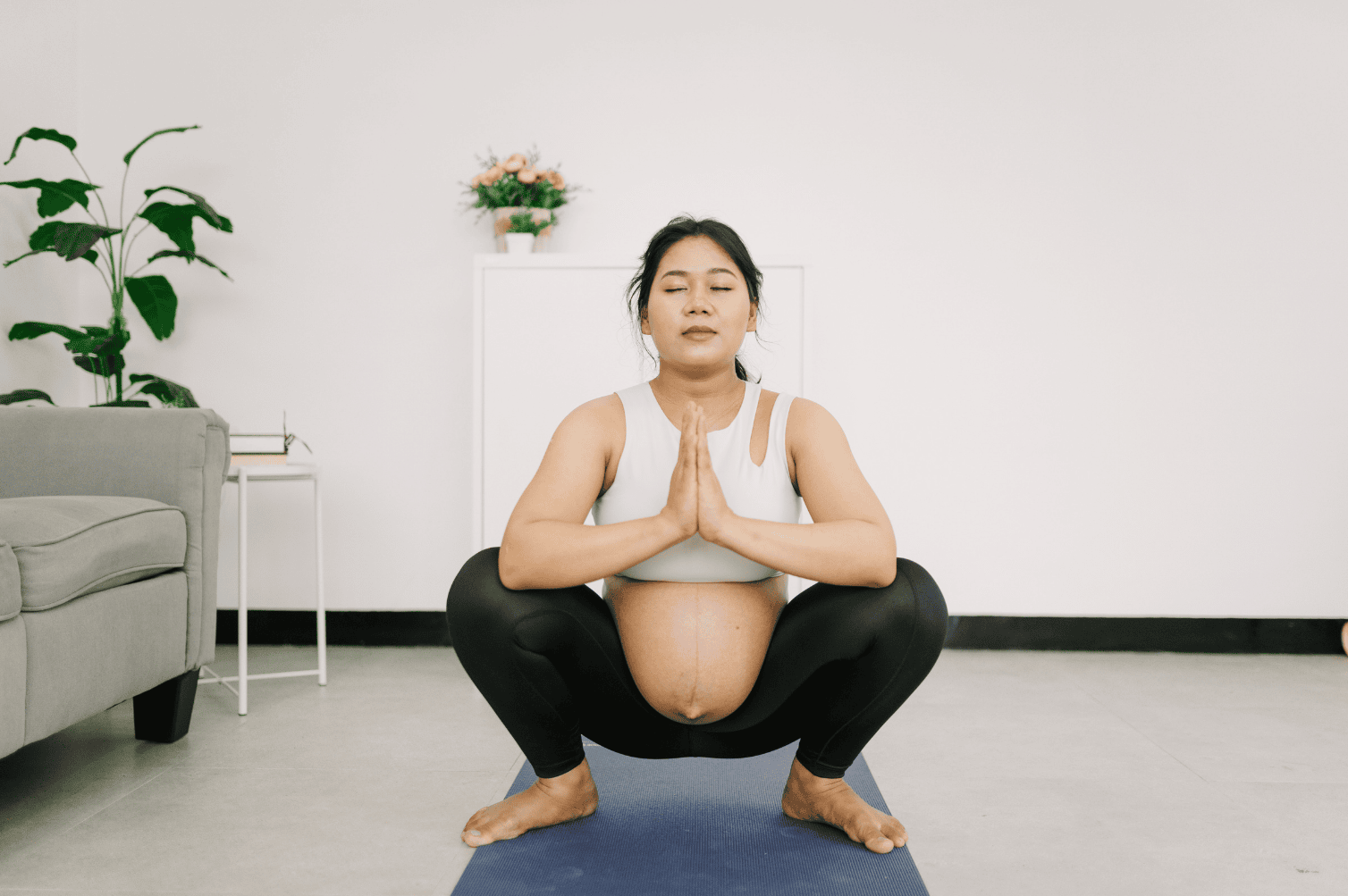 pregnant woman practices deep squats to help relax her pelvic floor